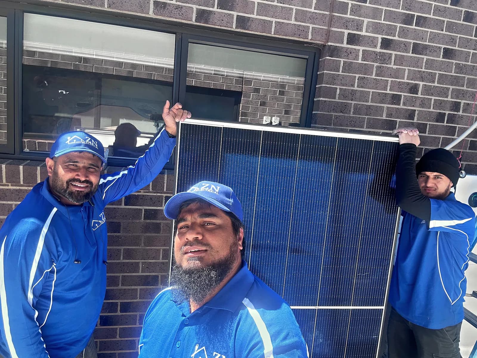 ZN Electrical electricians on site with a solar panel ready for installation